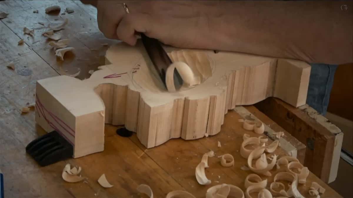 Large gouge sinking a hollow while curled shavings pile across the bench