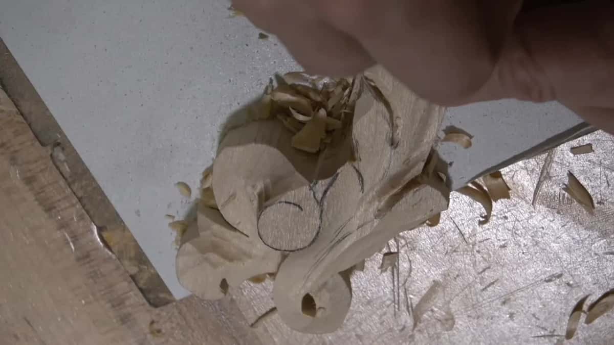 Carved scroll and its eye, ridge standing above the hollows on either side.