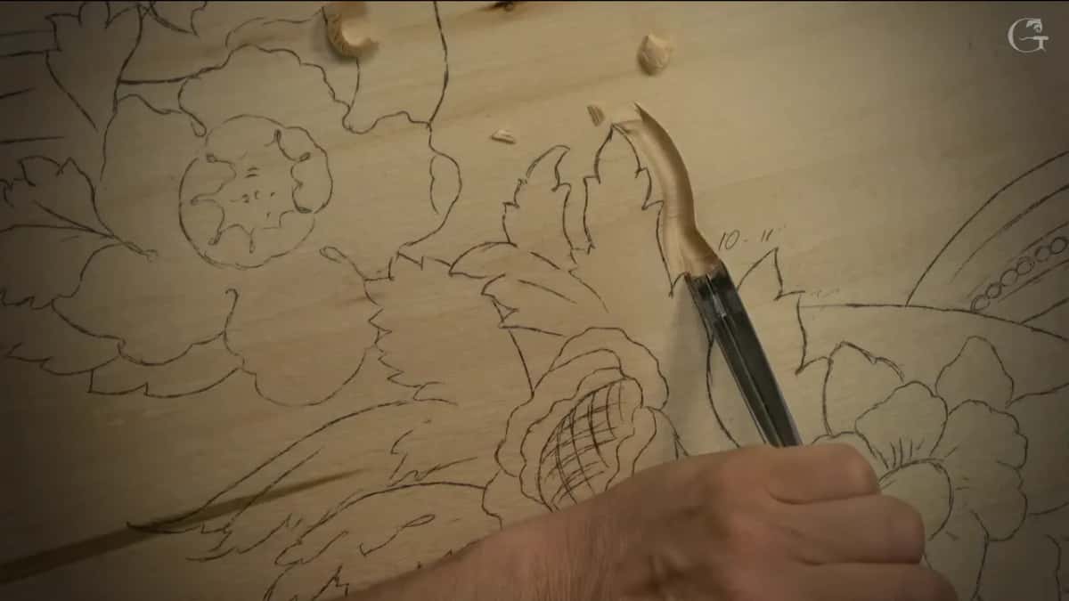 The gouge sits in a fresh groove beside a leaf, a small pencil note next to it