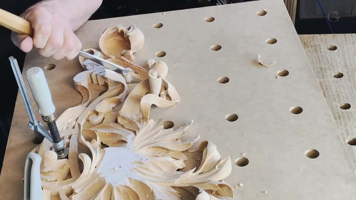 A tool works between the petals of a clamped flower