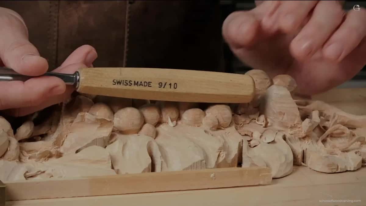 Tool stamped SWISS MADE 9/10 held above the carving, which is a number 9 at ten millimetres