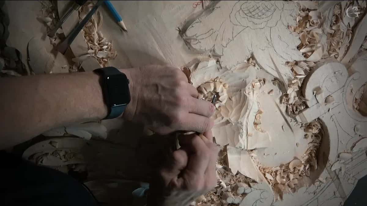 Wrists low over a small gouge, blue pencil parked above