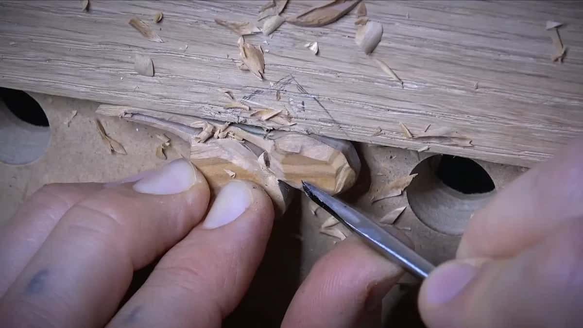 Blade tip working between two faceted olives, with the scrap of oak close behind them
