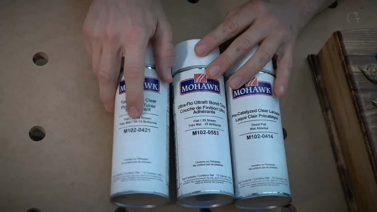 Mohawk spray cans lined up on the bench, three of them, labels facing the camera