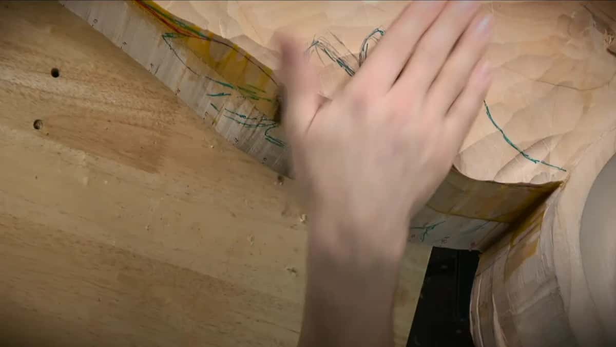 Two surfaces Blurred hand sweeping across the roughed face, teal marks and a taped rule at the edge