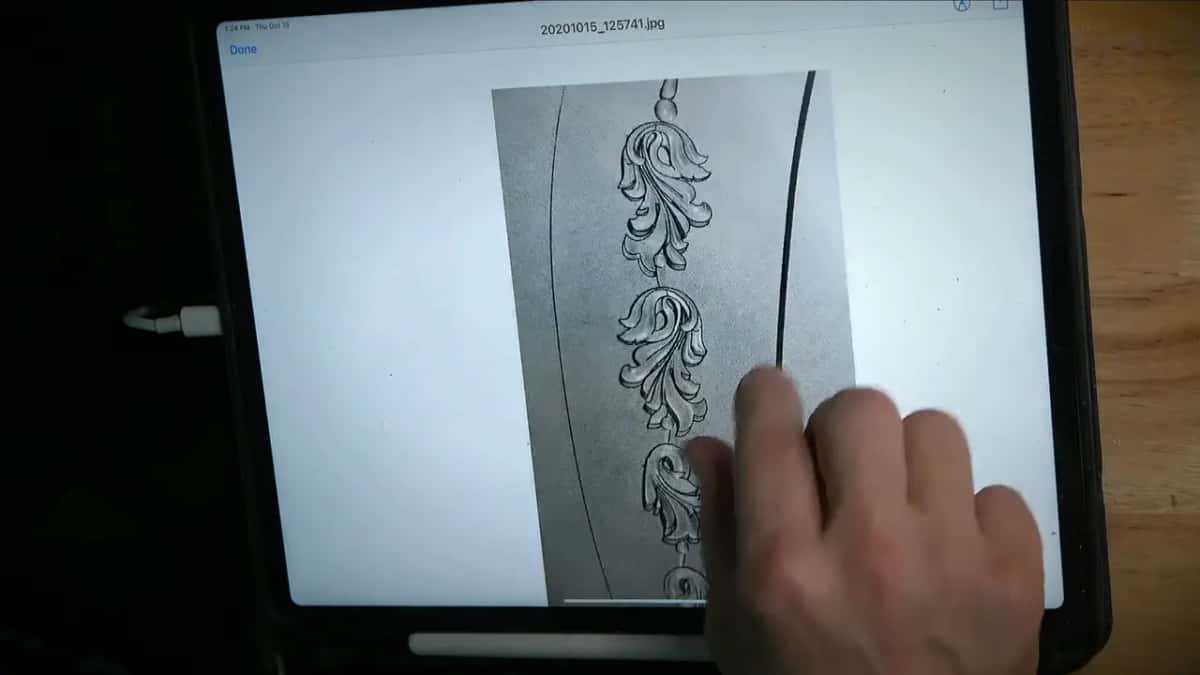 Pinching it bigger iPad screen showing a photograph of the printed drawing, one hand pinching the glass