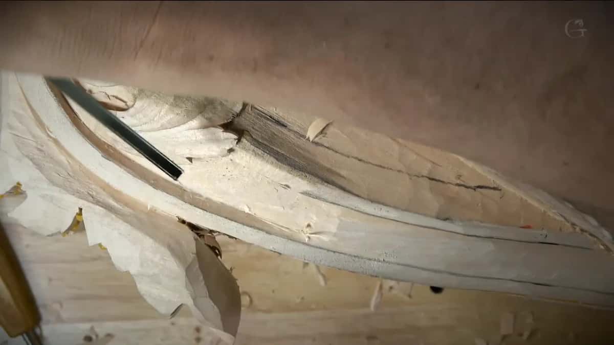 Fluteroni Dark blade laid along a long shaped edge with the forearm behind it