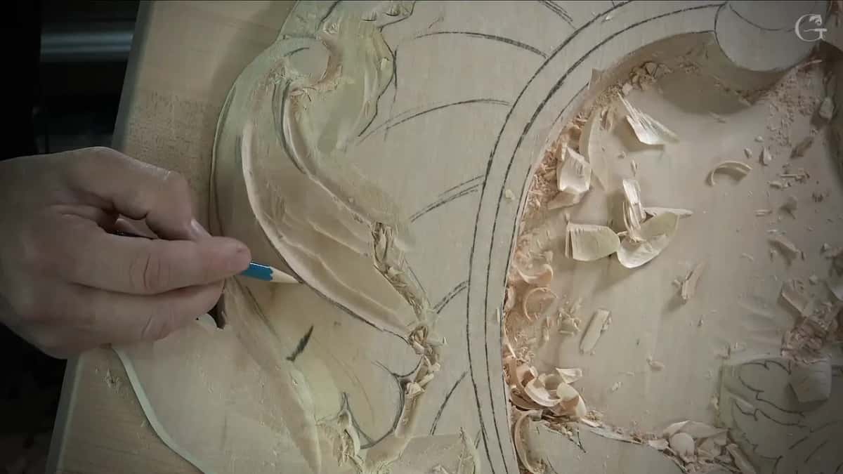 Blue pencil marking the middle line along the leaf, shavings piled in the hollow to the right