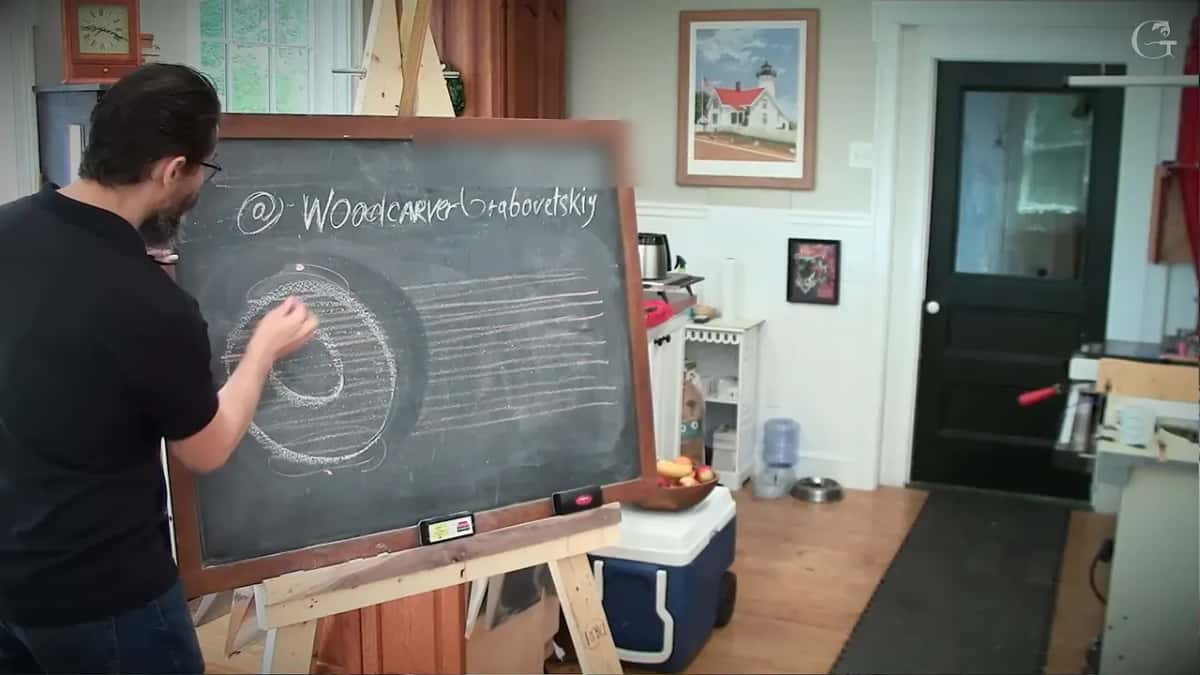 Chalk donut drawn over the grain lines of a board, his hand pointing at the ring