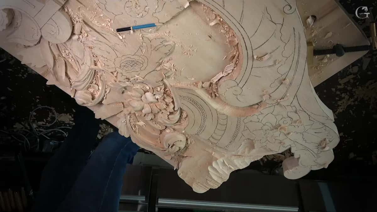 Board seen from the low side, a blue pencil lying across the carved area