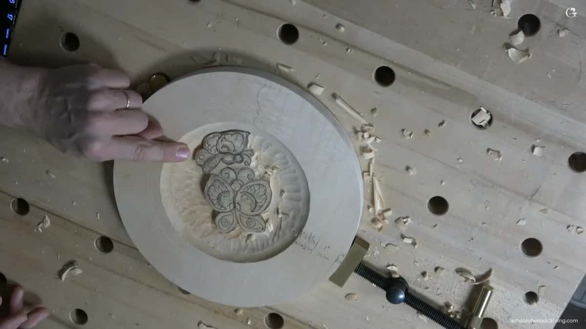 Chips cover the bench around the plate, which a clamp holds at one side