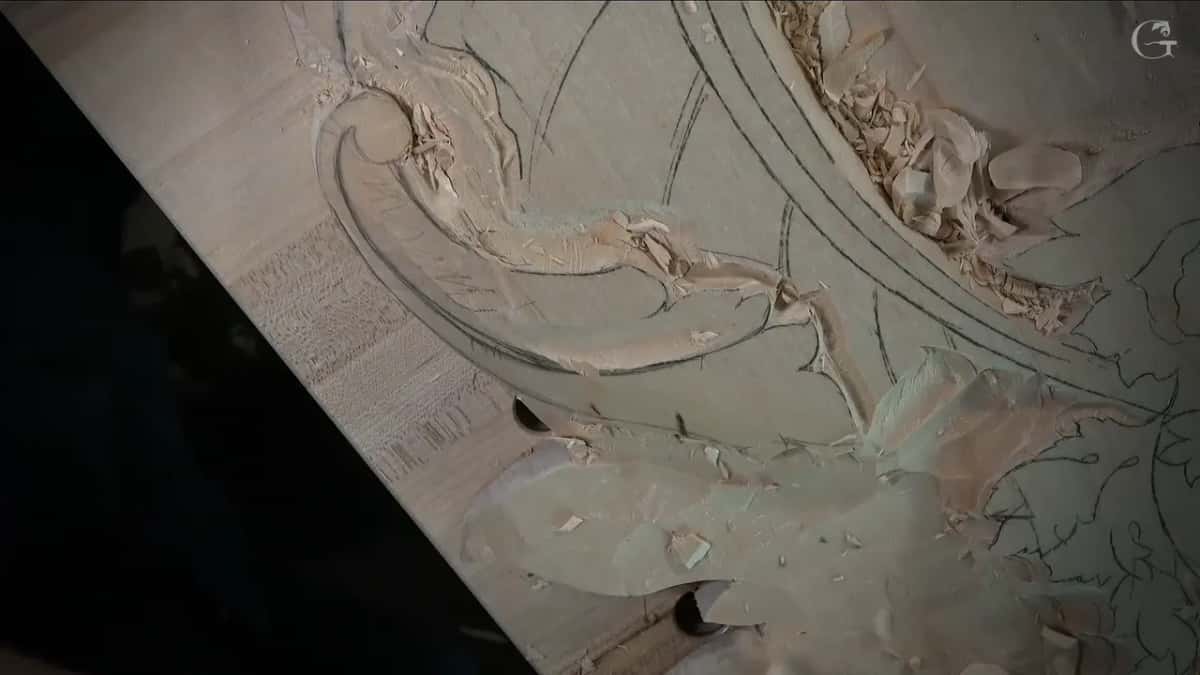 Sloped leaf and volute seen from above with no hands in the way, shavings scattered on the panel