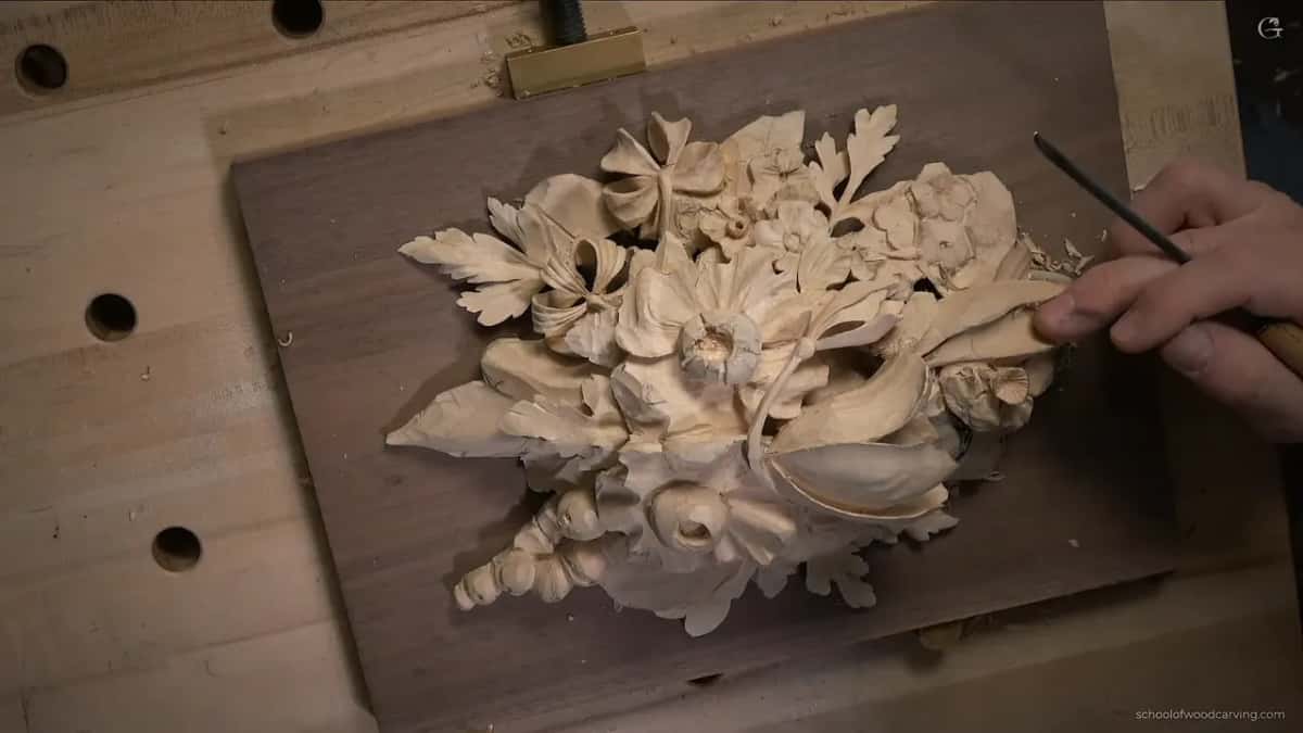 From above, a gouge working the curl on the right side of the panel while the other flowers wait