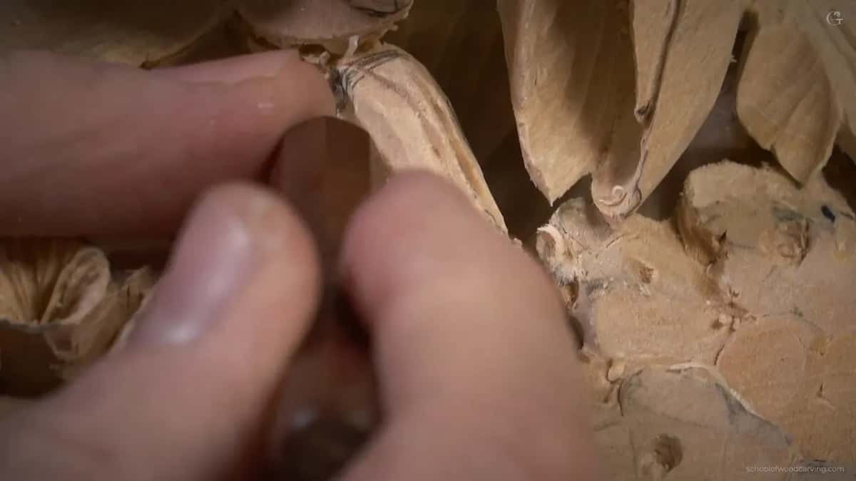 Fingers pinching the tiny skew with its dark handle