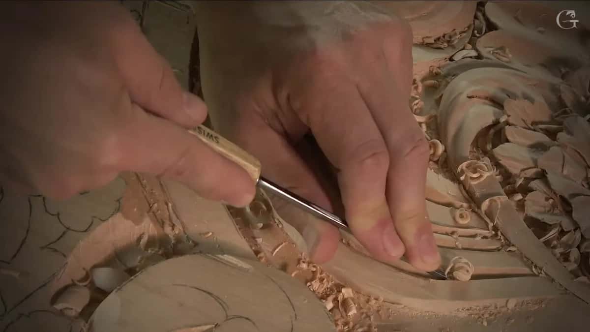 One hand guides a long, slim blade into the narrow groove