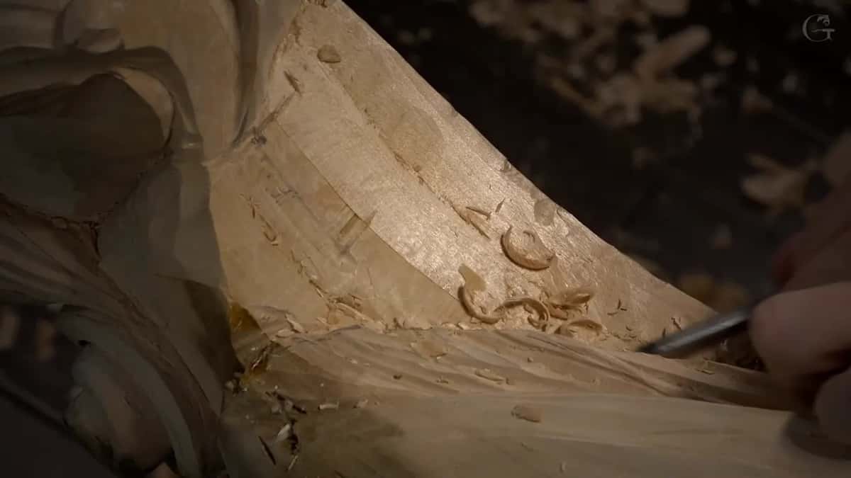 A veiner runs along the line under a raised edge, and curled chips sit on the surface beside it.