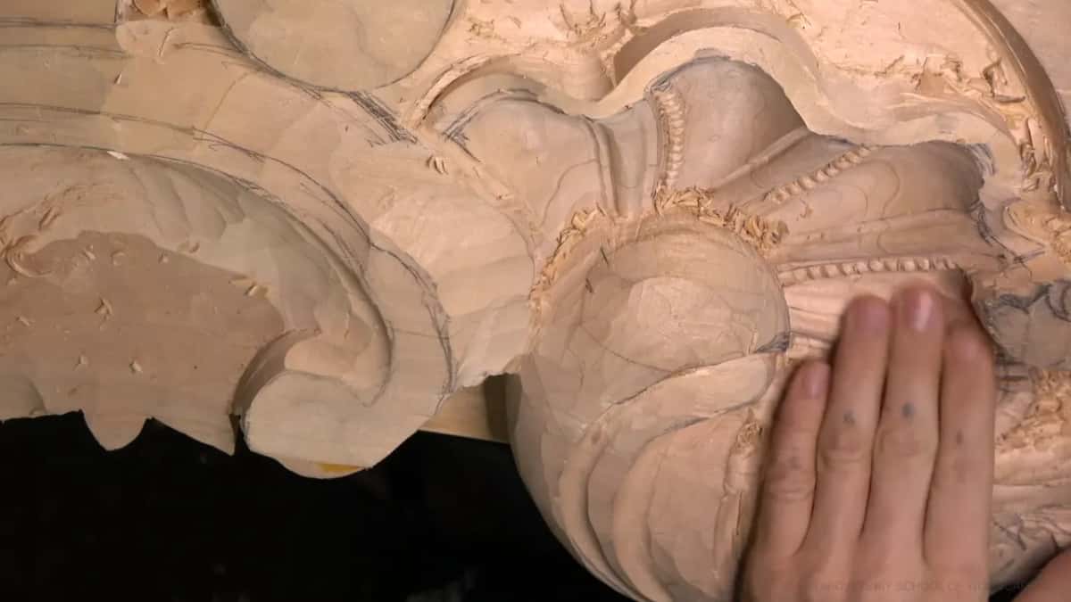 An open palm rests near rows of small carved beads.