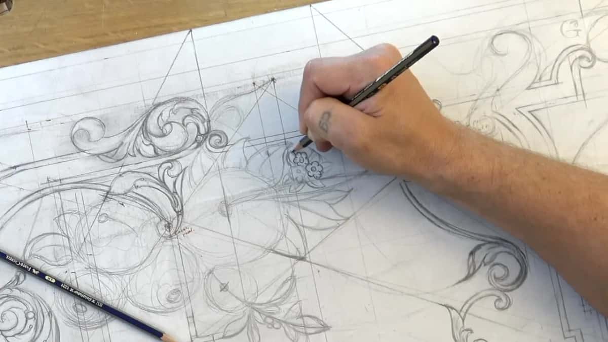 Two tiny flowers going in by a leaf in black pencil, a blue pencil lying on the paper at left