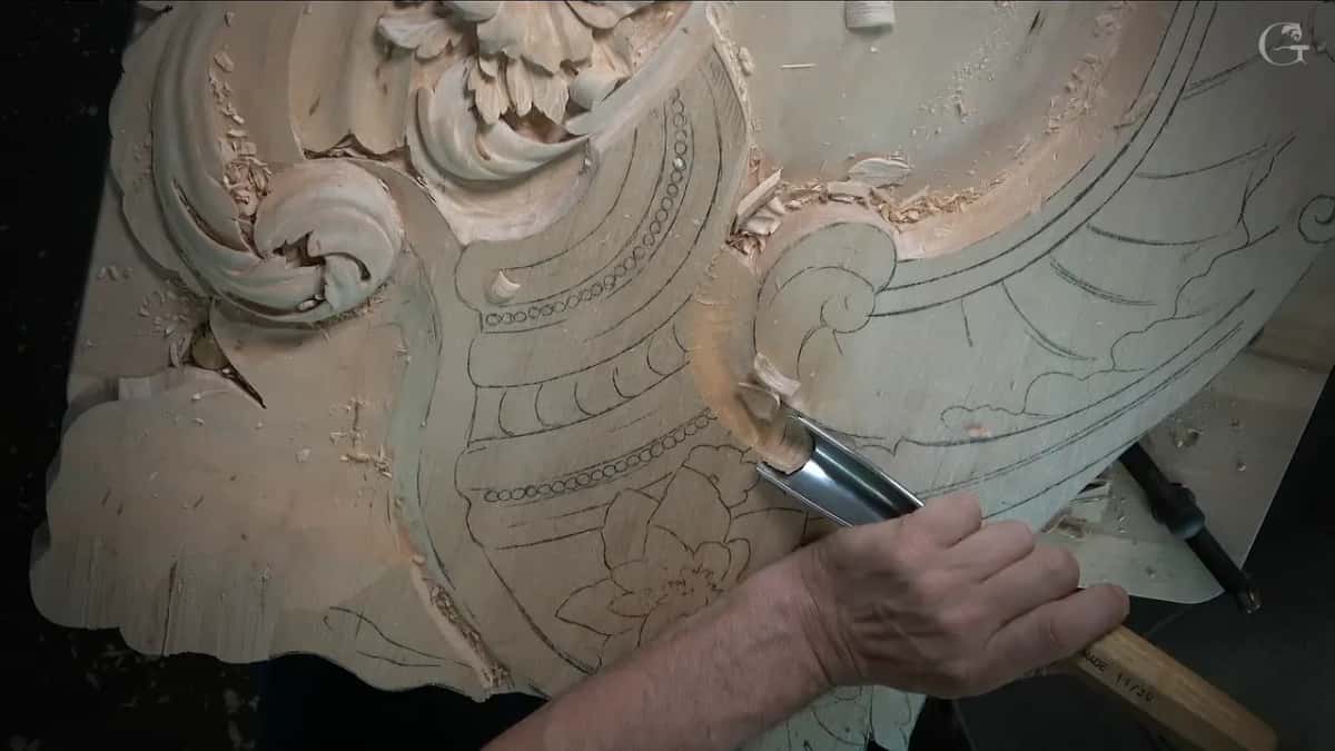A wide U shaped gouge held low against the drawn outline of the upper part