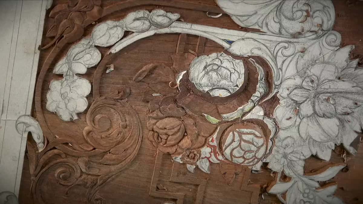 Carved roses in a circle, one still under paper, the rest opened up into bare wood