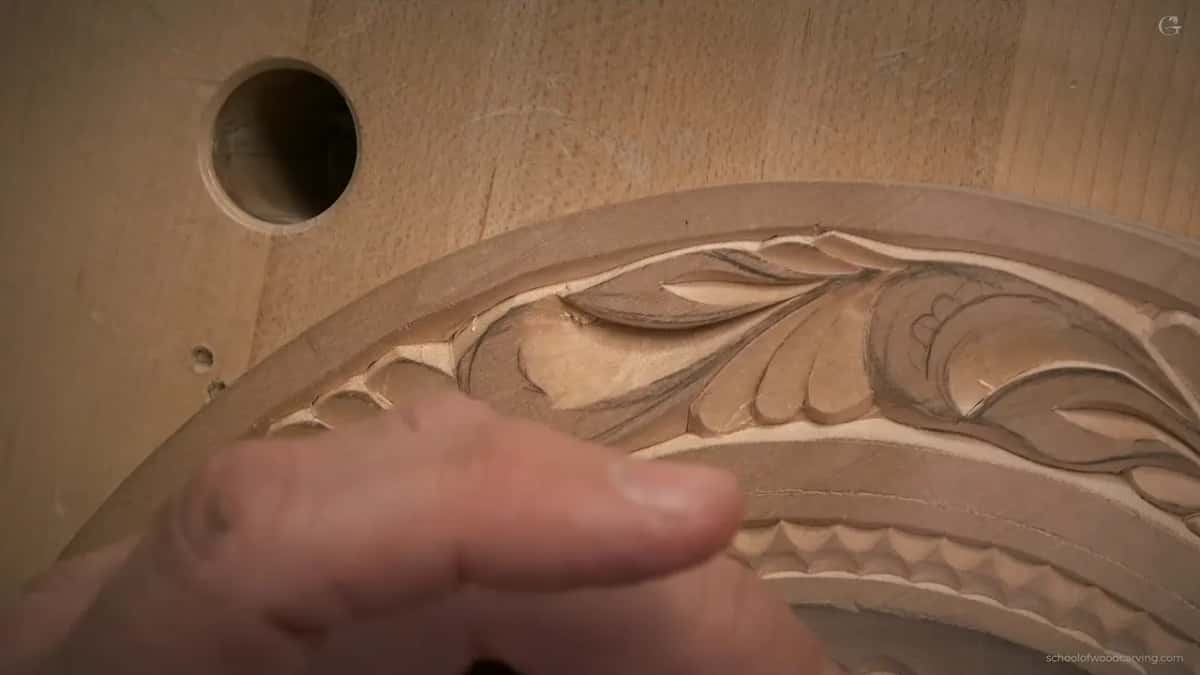 Fingertip over leaves already carved