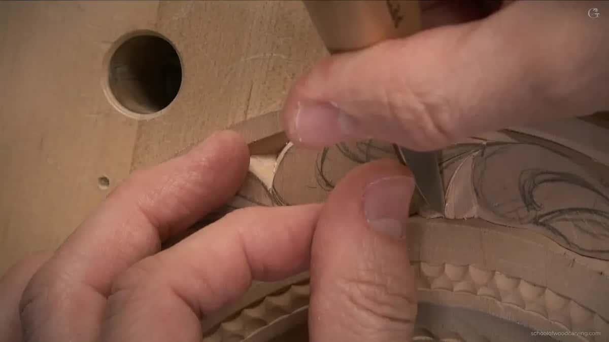 Thumb and two fingers hold the knife right at the edge of the band