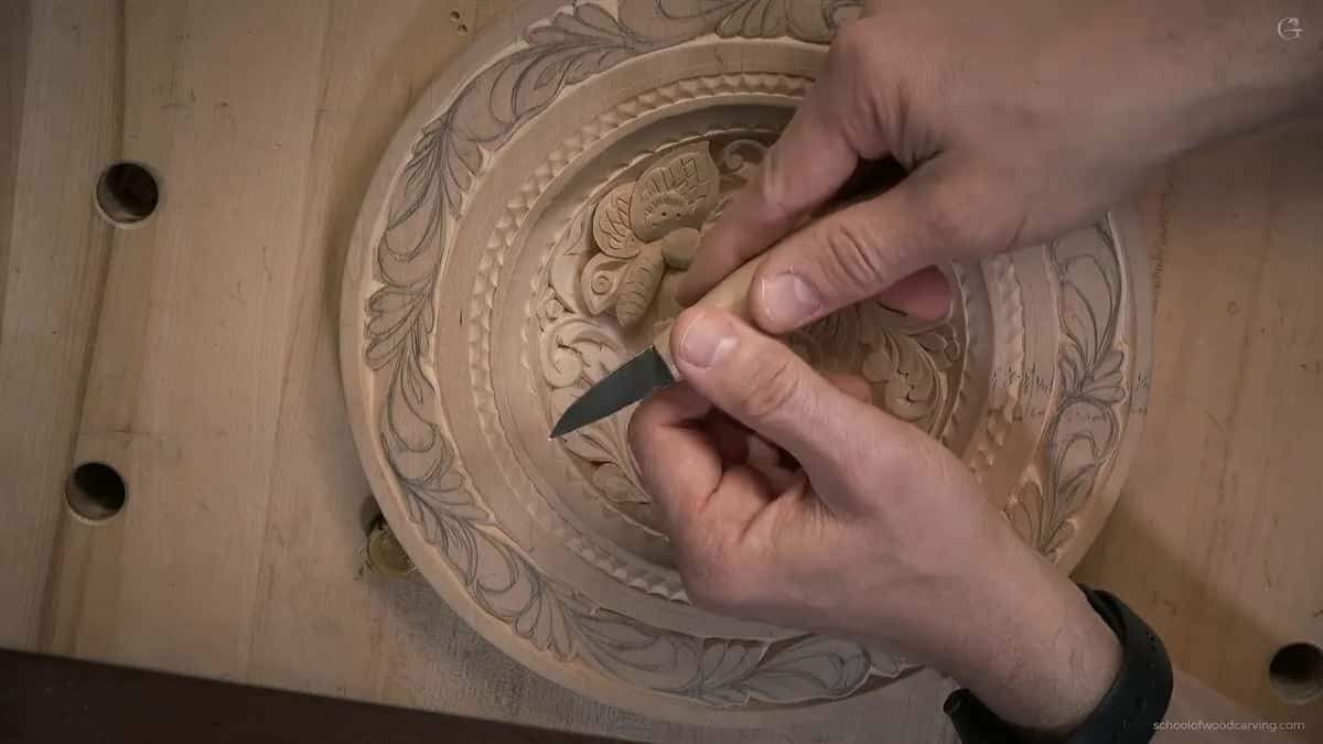 Both hands keep a pale-handled knife low near the rim