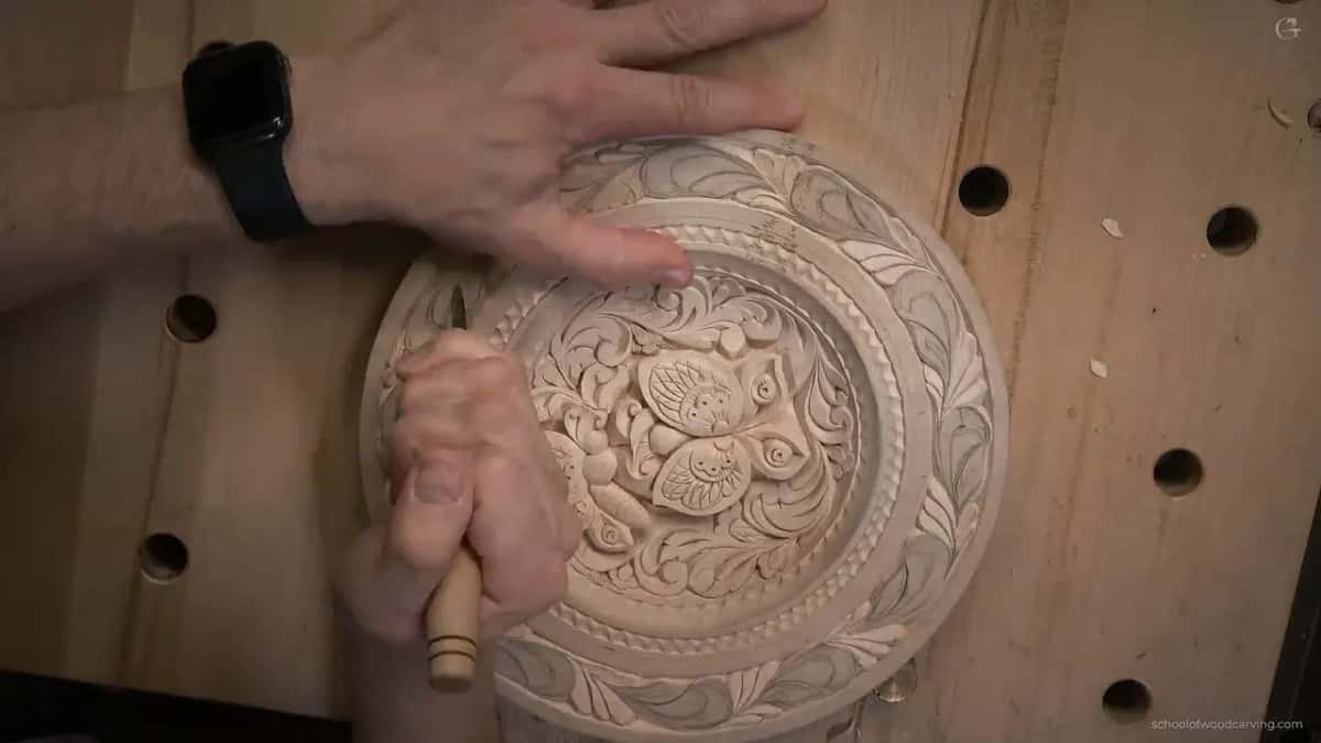 One hand spread flat on the plate, the other standing a knife upright near the lower rim