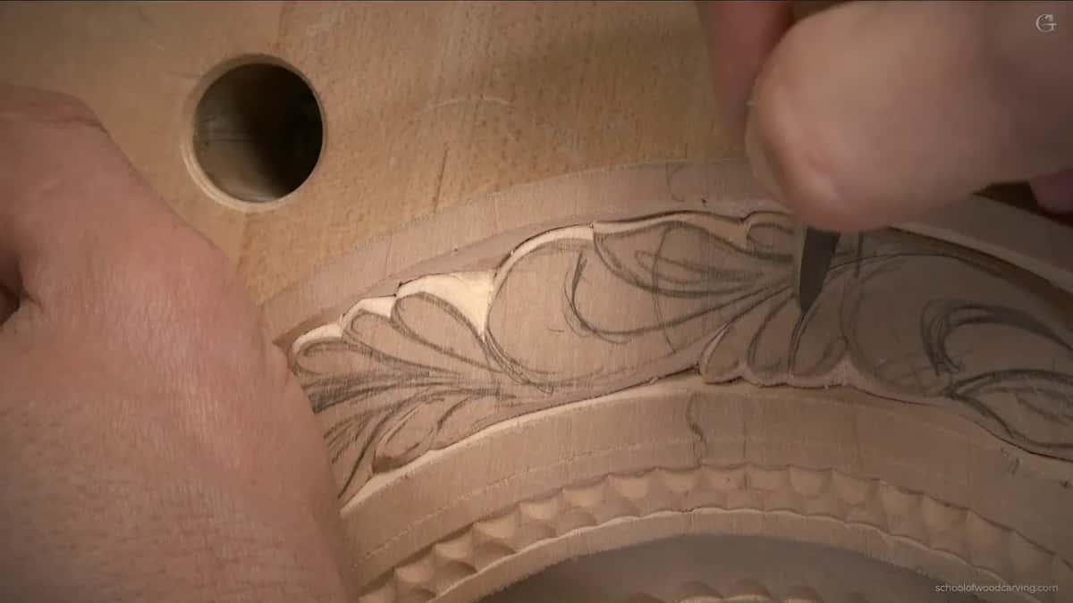 Fingertips press the handle down while the blade finishes one short line in the band