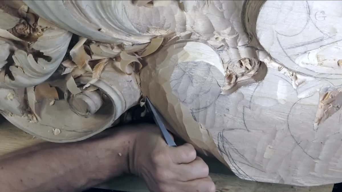 Against the big smooth mass of the head, a flat blade and pencil curves beside it.