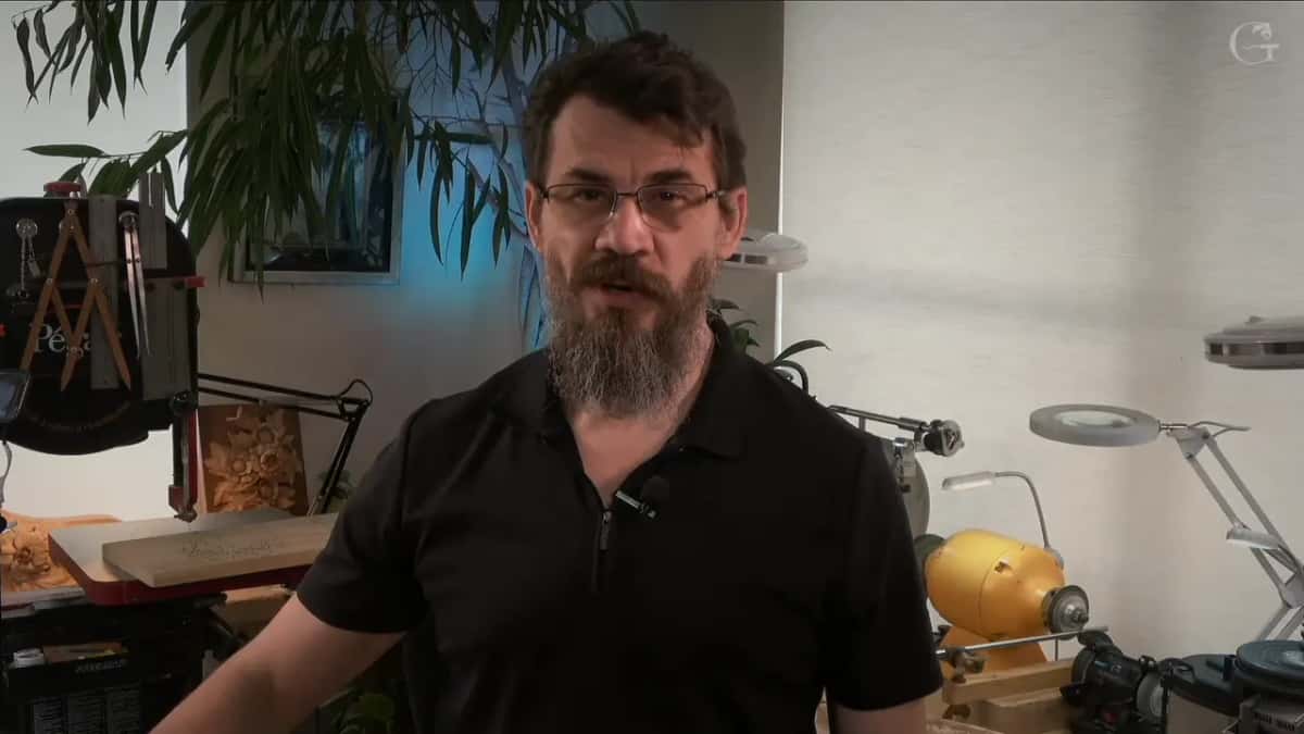 Alexander Grabovetskiy explaining the workshop with the scroll saw and the grinder behind him