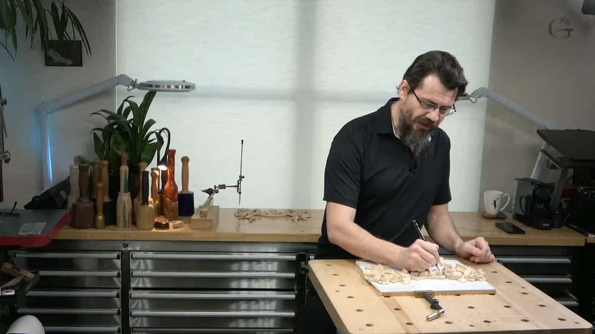 Working at the bench, panel clamped flat, tools ranged along the shelf