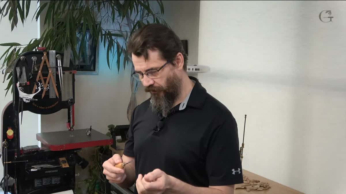 Examining a small gouge held up in front of him
