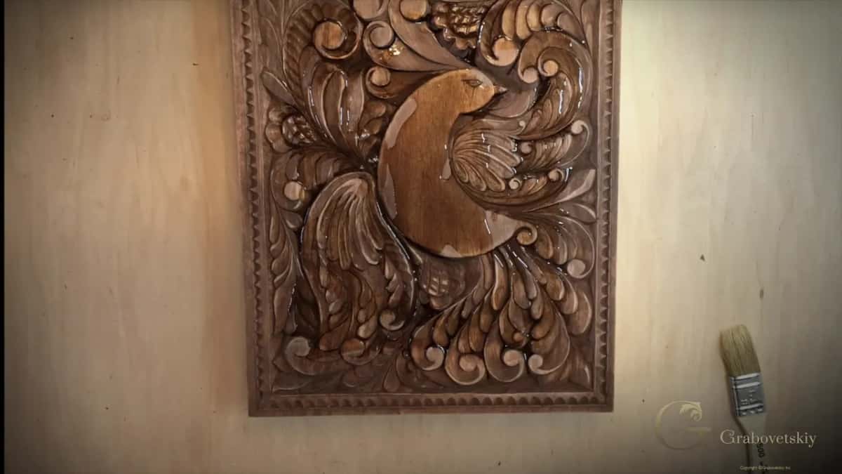 Oil poured straight onto the carving with a brush waiting beside it, and generosity here is the whole trick.
