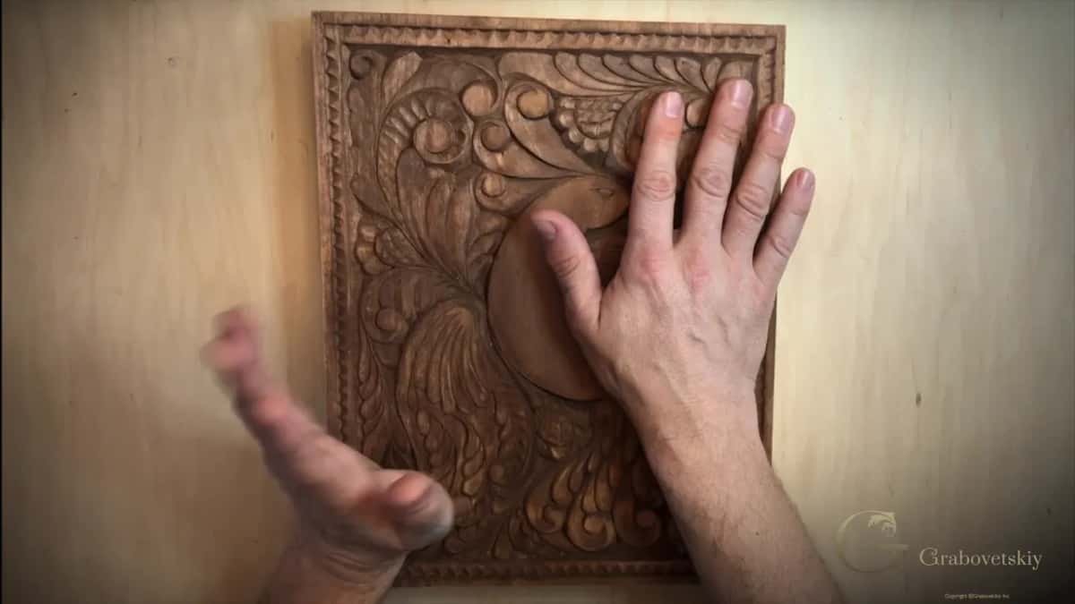 Flat hand on the carved face, the side that will never meet a kitchen knife.