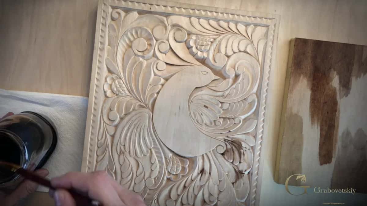 Test piece standing beside the panel, half of it dark and half still bare.