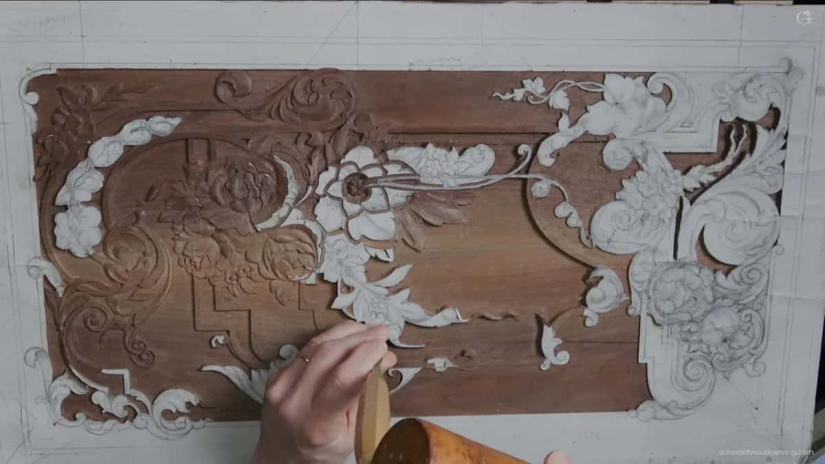 A mallet in one fist above the whole panel, seen from directly overhead, with white pattern paper stuck across most of it.