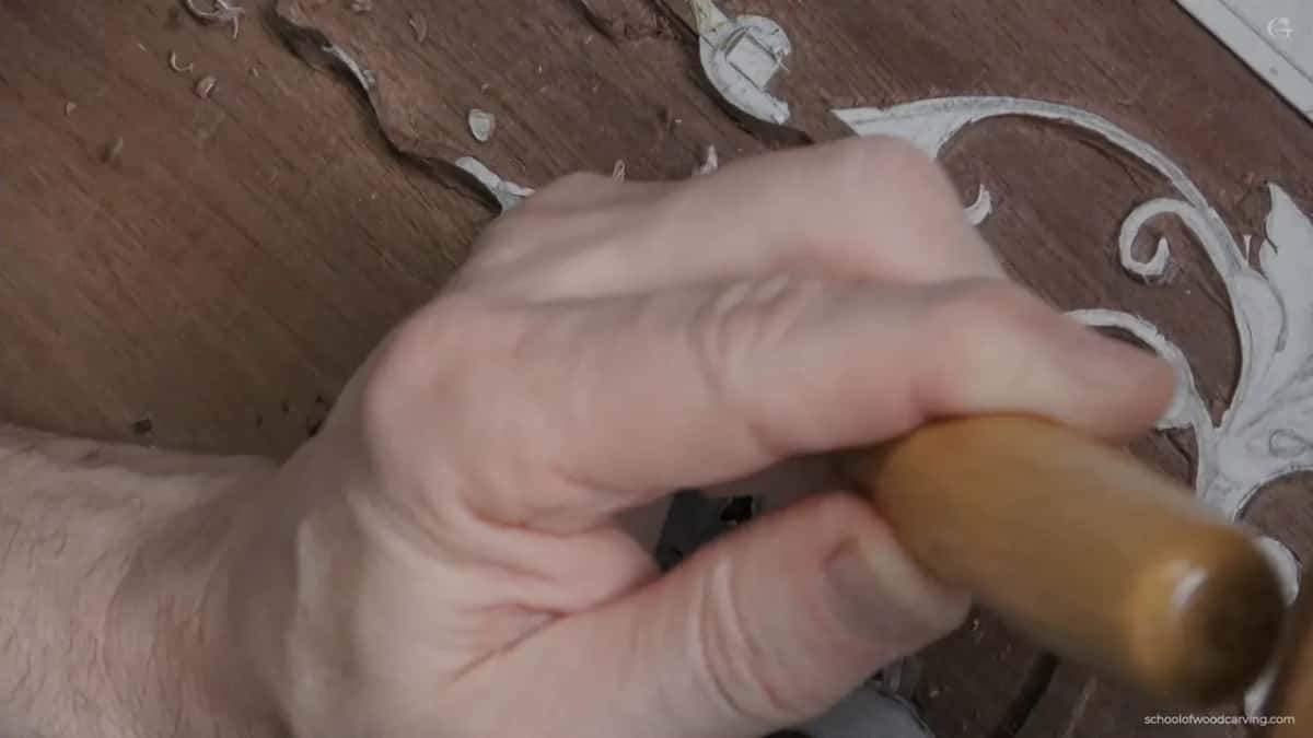 Blurred hand, tan handle.