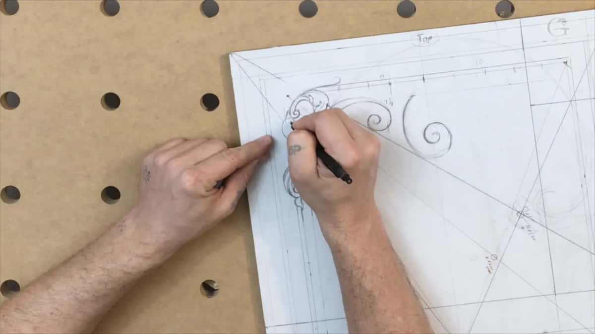 One hand points while the other draws at the corner, with the word Top written above the panel edge