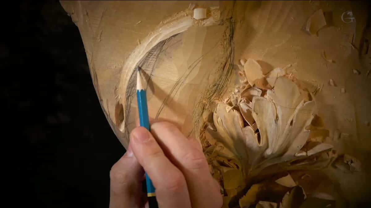 An arc in a hollow One blue pencil marking an arc inside a hollow, shavings piled to the right, black behind all of it