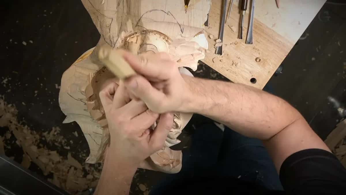 Both hands guiding a gouge down a hollow