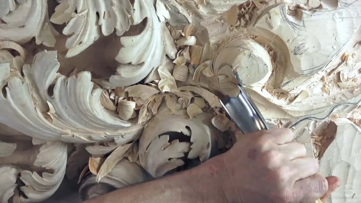 Chips pile up where a broad gouge scoops the hollow bowl.