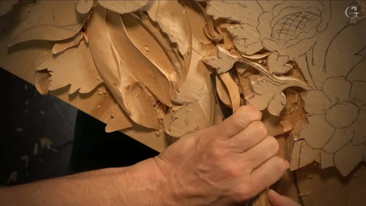 A curl of wood rises off the gouge