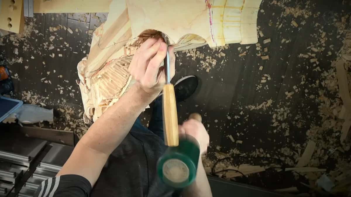 Gouge held straight up on the drop, a green mallet ready in the other hand