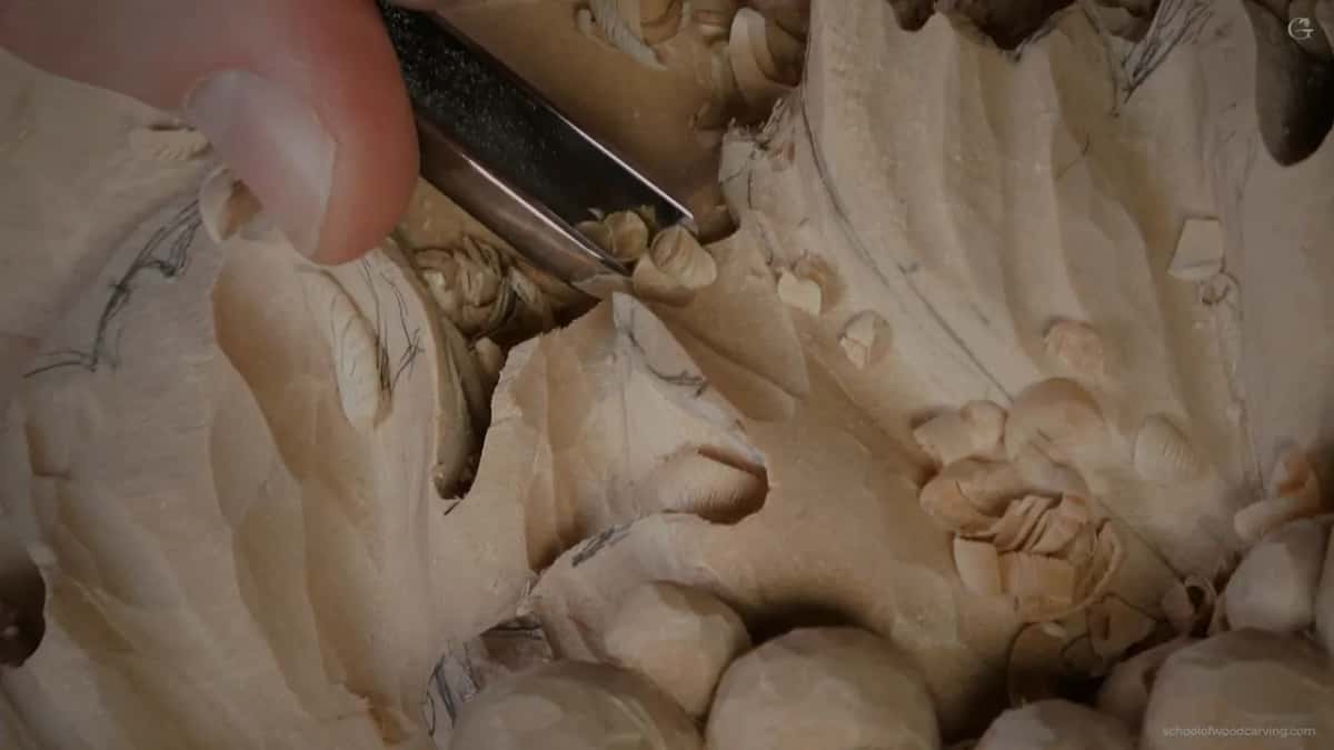 Gouge working under a pencil marked lobe, chips piling where the undercut is being taken back