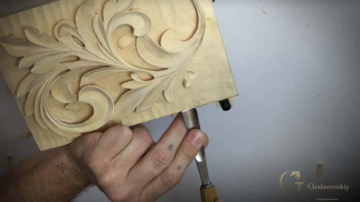 Seen from above, one fist holds a gouge upright at the bottom of the panel