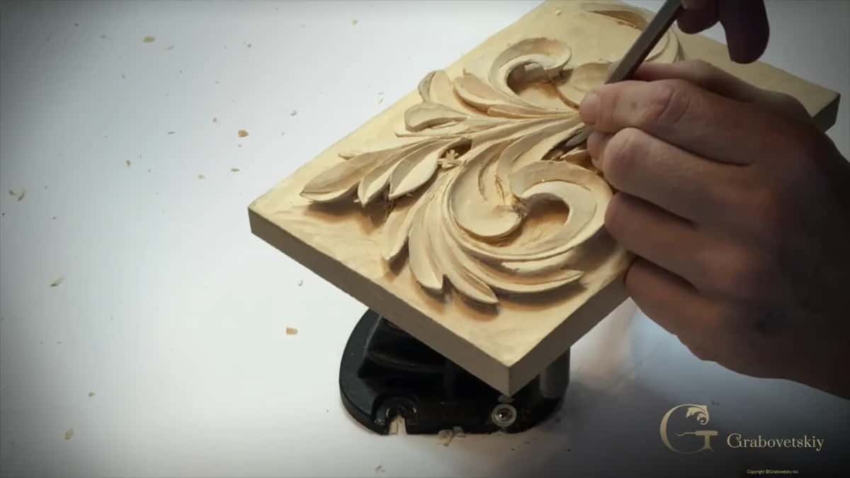 A decorative piece, not furniture, with a straight tool near the upper edge of the big scroll