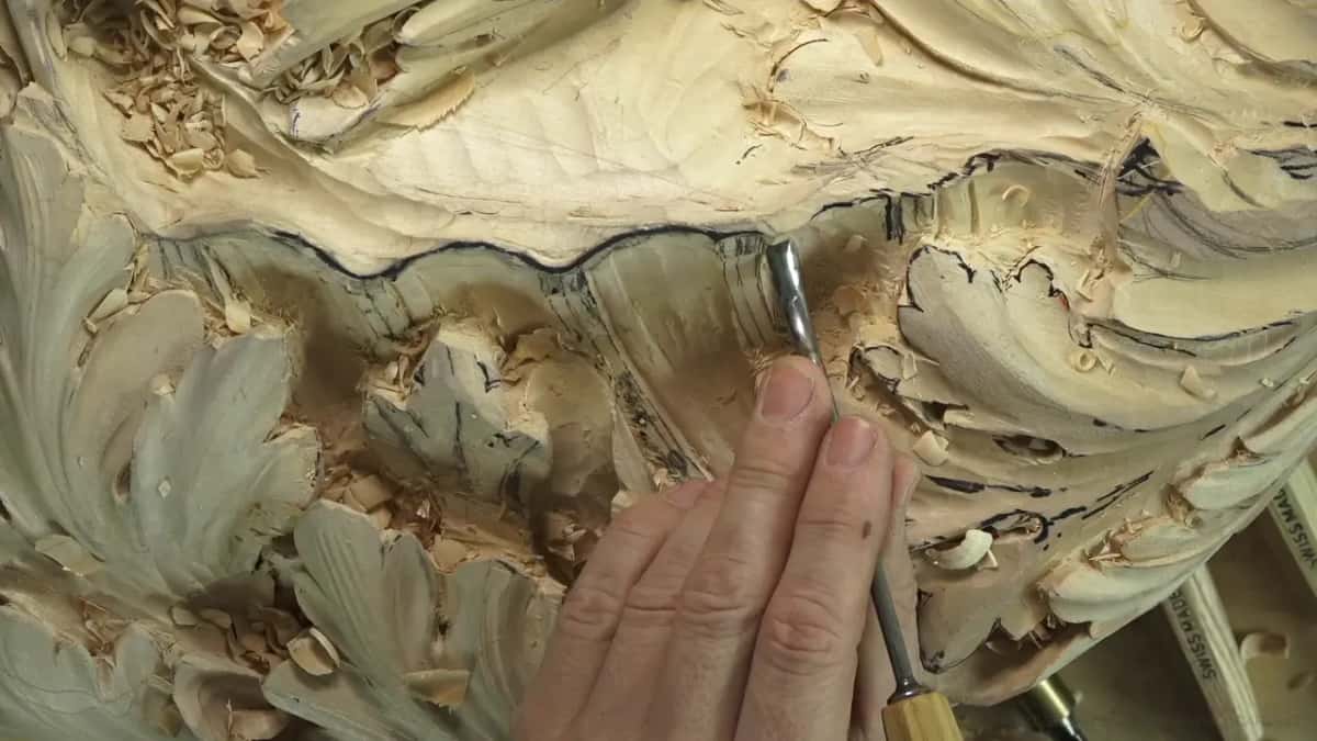 Set against the shell's edge, a small straight gouge.