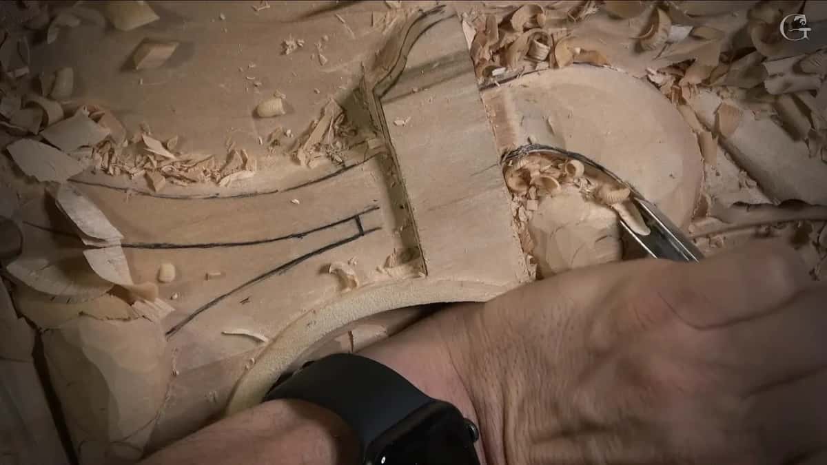 Tool reaching in under a leaf that rolls up from beneath, a wrist resting on the panel