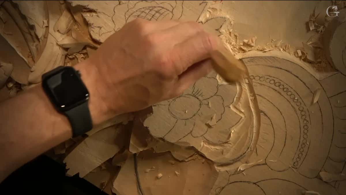 Wrist with a watch, gouge low near the flower.